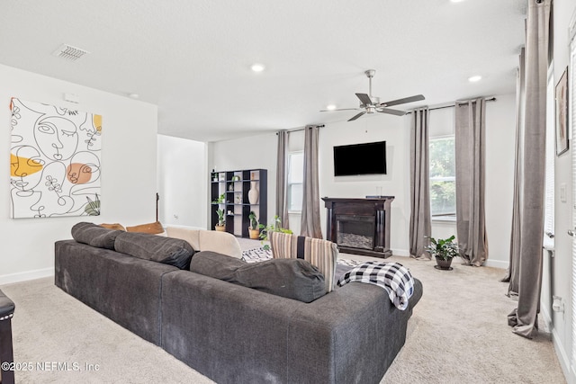 carpeted living area with visible vents, baseboards, ceiling fan, recessed lighting, and a fireplace