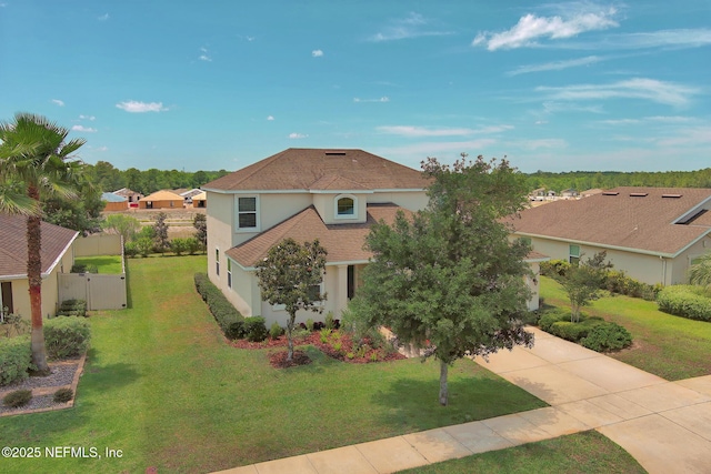 view of front of house with a front yard, a gate, concrete driveway, and stucco siding