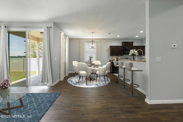 dining space featuring dark wood finished floors, recessed lighting, a textured ceiling, and baseboards