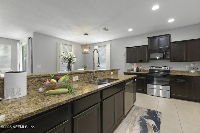 kitchen with dark stone counters, light tile patterned floors, recessed lighting, appliances with stainless steel finishes, and a sink