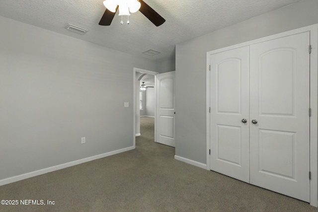 unfurnished bedroom featuring visible vents, baseboards, carpet floors, a closet, and a textured ceiling