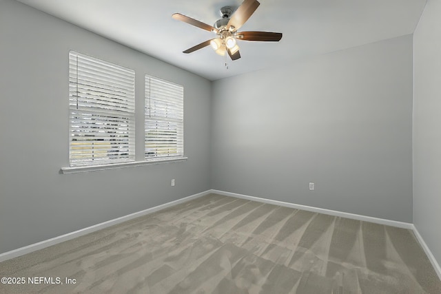 empty room featuring a ceiling fan, baseboards, and light carpet