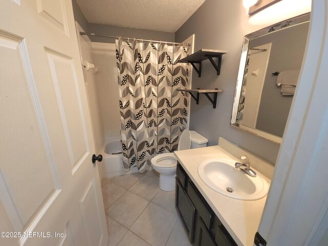 bathroom featuring tile patterned floors, shower / bath combo with shower curtain, toilet, a textured ceiling, and vanity