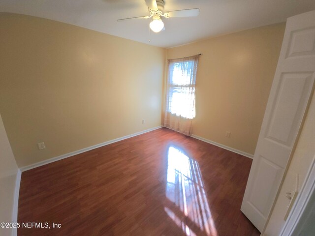 unfurnished room featuring wood finished floors, baseboards, and ceiling fan