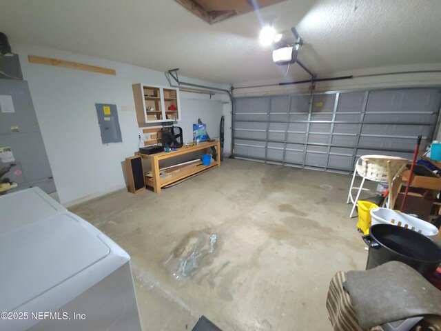 garage featuring electric panel, heating unit, washer / dryer, and a garage door opener