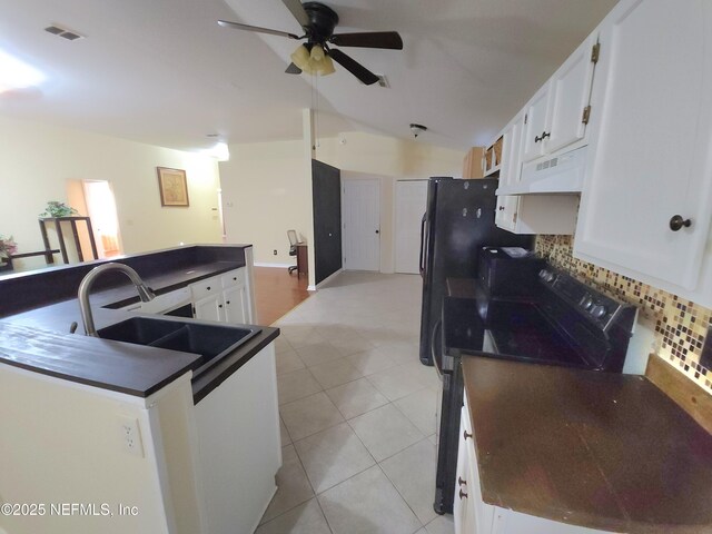 kitchen featuring visible vents, a sink, under cabinet range hood, dark countertops, and black electric range oven