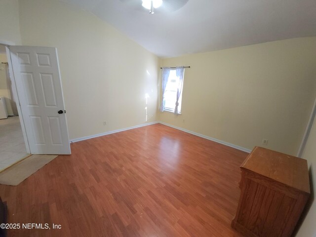 interior space featuring vaulted ceiling, baseboards, light wood finished floors, and ceiling fan