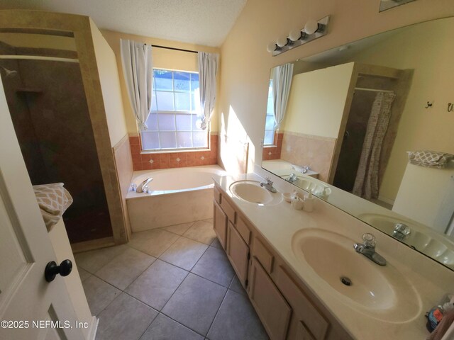 full bath with a garden tub, a sink, a textured ceiling, a shower stall, and tile patterned flooring