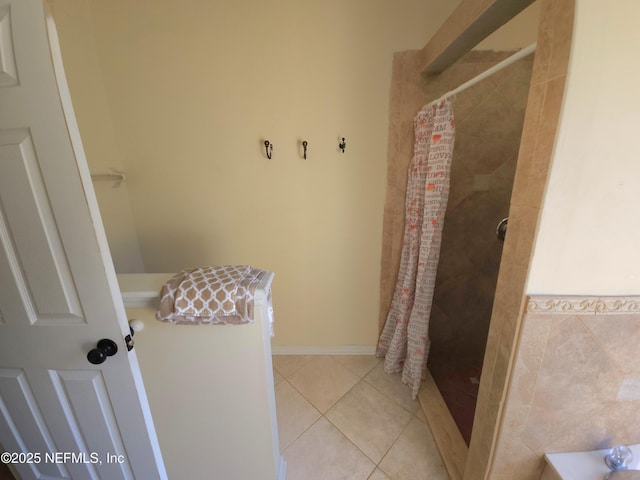 bathroom featuring tile patterned flooring and tiled shower