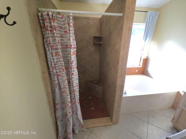 bathroom featuring tile patterned floors, a garden tub, and a stall shower