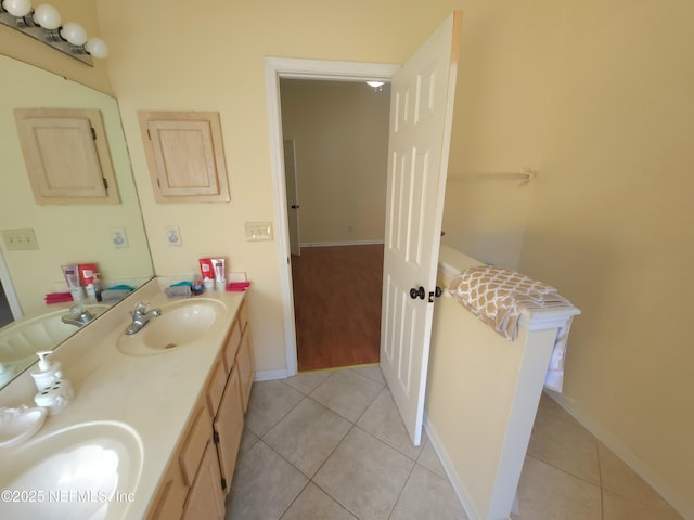 bathroom featuring tile patterned floors, double vanity, and a sink