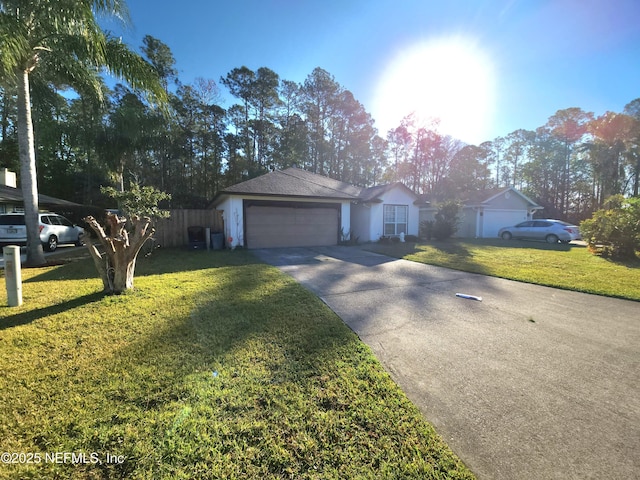 ranch-style home featuring a garage, driveway, a front lawn, and fence