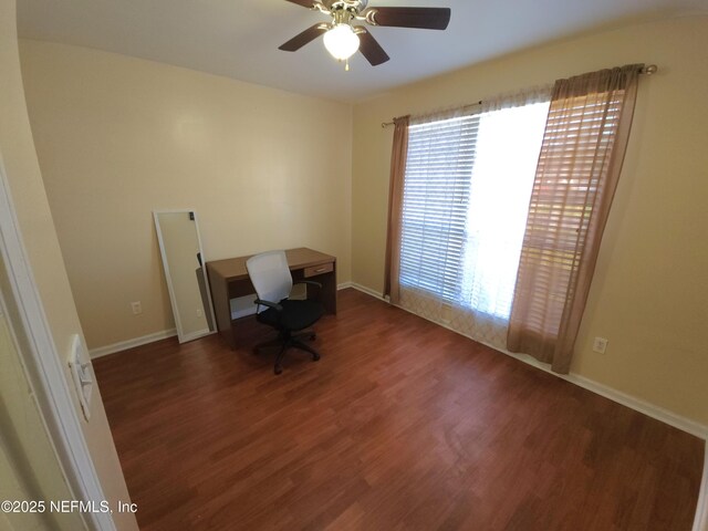 unfurnished office featuring wood finished floors, baseboards, and ceiling fan