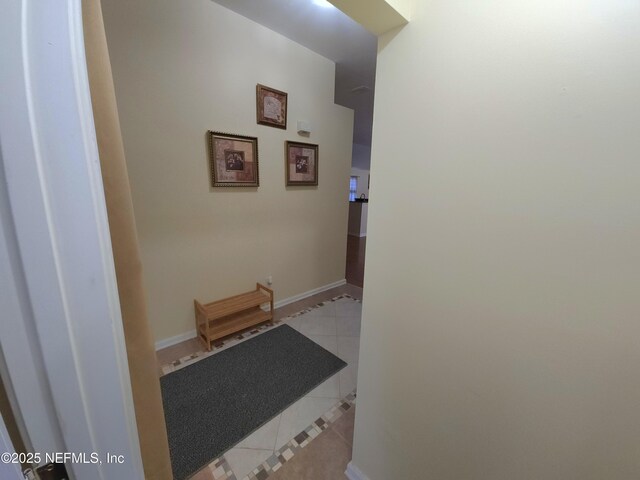 hall with light tile patterned floors and baseboards