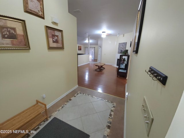 hall with tile patterned floors and baseboards