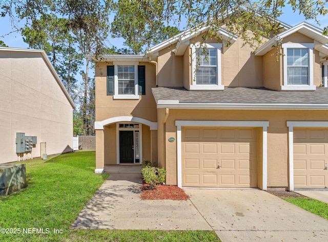 view of front facade with stucco siding, an attached garage, concrete driveway, and a front yard