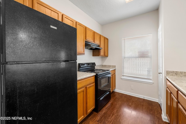 kitchen featuring under cabinet range hood, black appliances, light countertops, and dark wood-style flooring