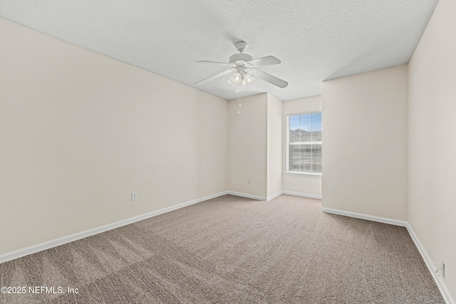 carpeted empty room featuring baseboards, a textured ceiling, and a ceiling fan