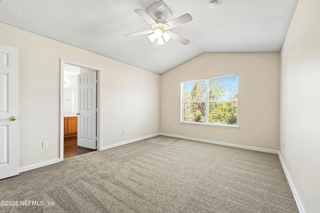 empty room with a textured ceiling, carpet, ceiling fan, and vaulted ceiling