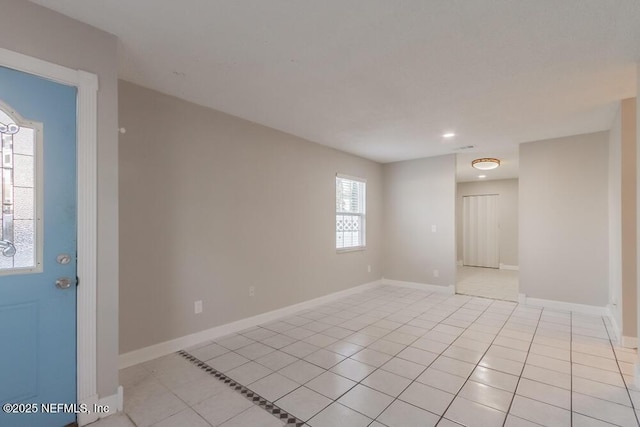 empty room featuring light tile patterned flooring and baseboards