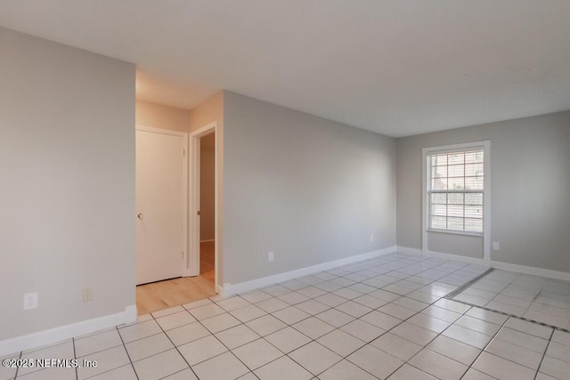 unfurnished room with baseboards and light tile patterned flooring