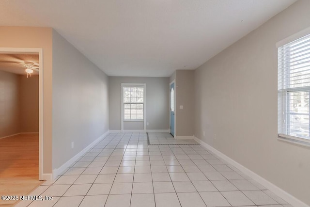 unfurnished room featuring baseboards and light tile patterned flooring