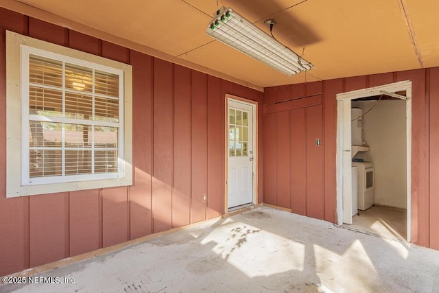 view of exterior entry with independent washer and dryer and board and batten siding