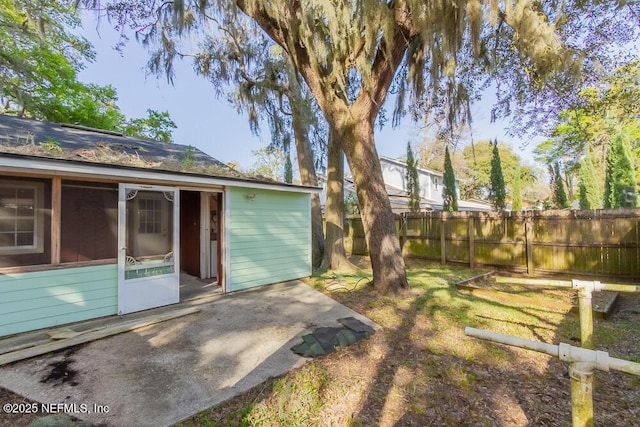 view of yard featuring a patio area, fence, and a sunroom