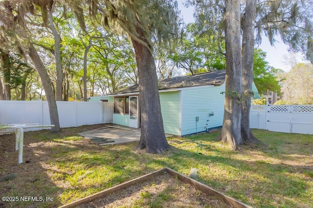 back of house with a yard and a fenced backyard