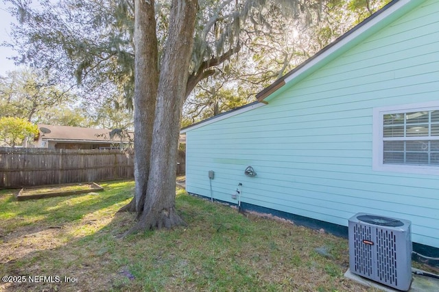 view of yard with central air condition unit and fence