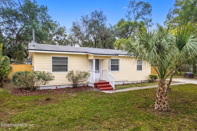 view of front of house with a front lawn and fence