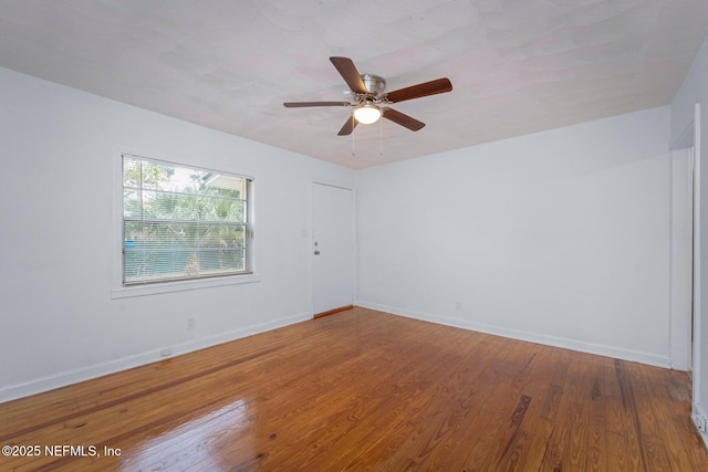 spare room with baseboards, a ceiling fan, and hardwood / wood-style flooring