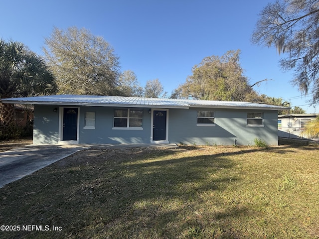 ranch-style home with a front lawn and metal roof