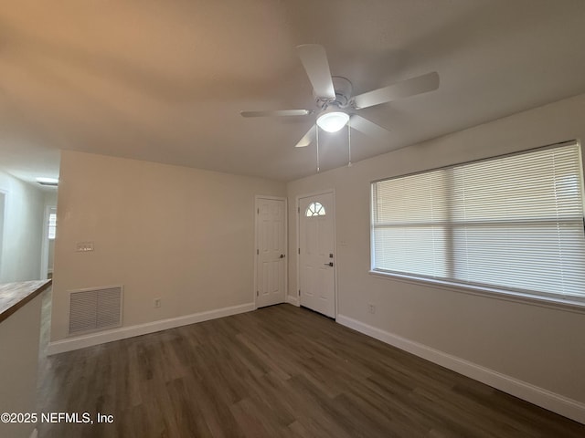 entryway featuring visible vents, ceiling fan, dark wood-type flooring, and baseboards