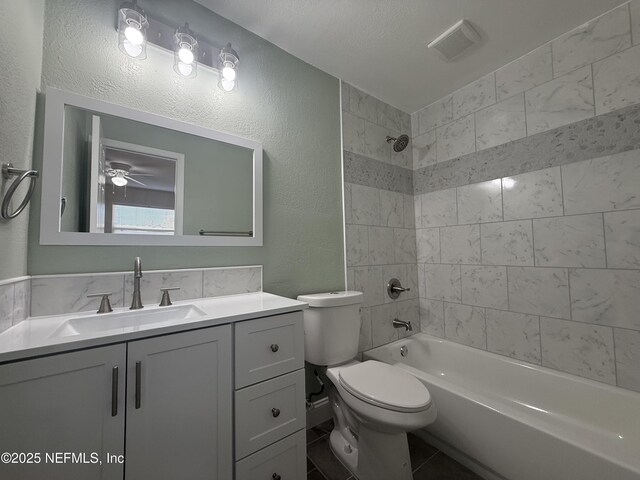 bathroom featuring visible vents, toilet, bathtub / shower combination, vanity, and a textured wall