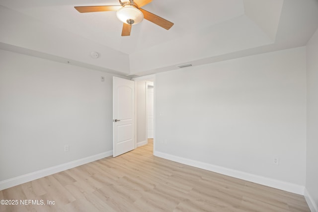 unfurnished room featuring a ceiling fan, visible vents, wood finished floors, and baseboards