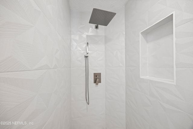 full bathroom with a tile shower and a textured ceiling