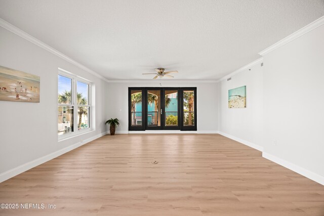 empty room with crown molding, baseboards, light wood finished floors, and ceiling fan