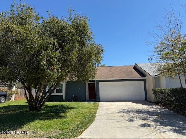 view of front of house featuring stucco siding, driveway, an attached garage, and a front yard