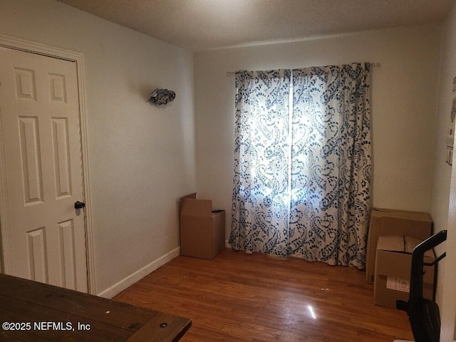 empty room featuring baseboards and wood finished floors