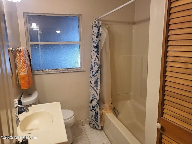 full bathroom with tile patterned floors, shower / bathtub combination with curtain, toilet, and a sink