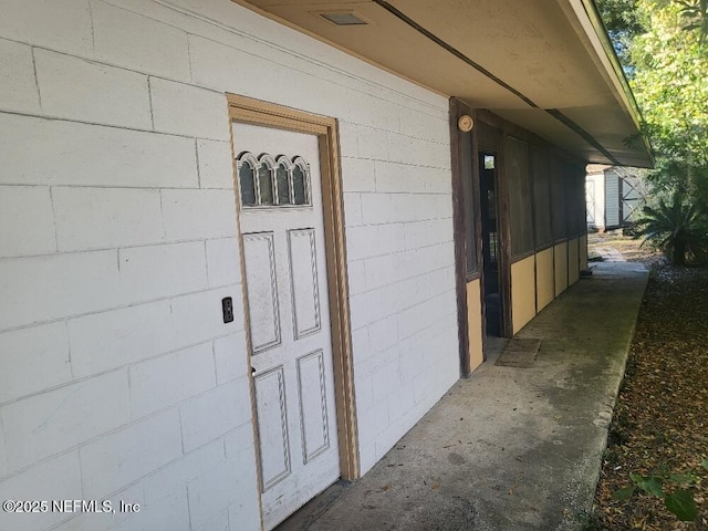 doorway to property featuring concrete block siding