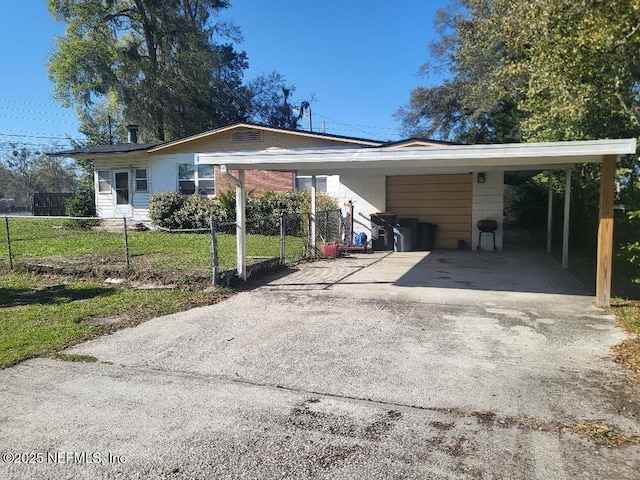 view of front of home with an attached carport, concrete driveway, and a fenced front yard