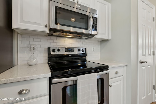 kitchen with stainless steel appliances, backsplash, and white cabinetry