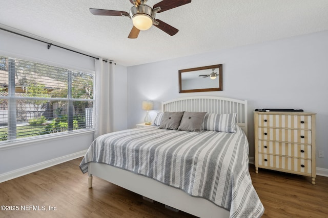 bedroom featuring ceiling fan, wood finished floors, baseboards, and a textured ceiling