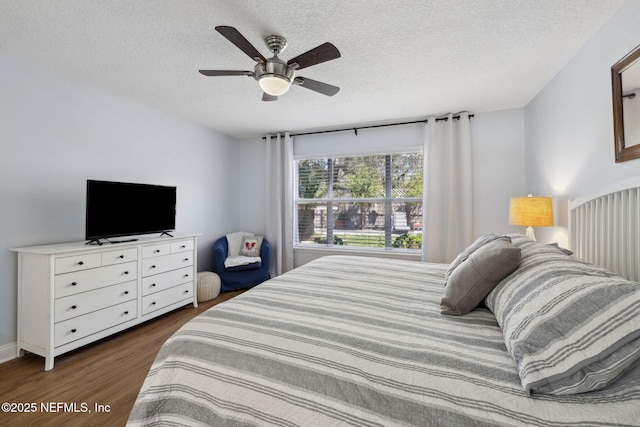 bedroom featuring a textured ceiling, dark wood-type flooring, and ceiling fan