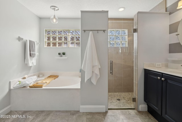 full bathroom featuring tile patterned floors, a textured ceiling, a shower stall, a bath, and vanity