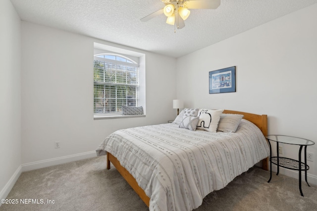 bedroom with carpet flooring, a ceiling fan, baseboards, and a textured ceiling