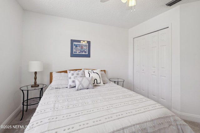 bedroom featuring a closet, visible vents, a textured ceiling, and carpet floors