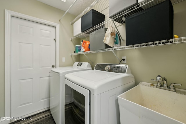 laundry room featuring laundry area, separate washer and dryer, and a sink